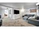 Bright open living room featuring a TV, a sectional sofa, air conditioner, and a view into the laundry room at 229 42Nd W St, Bradenton, FL 34209