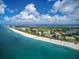 Breathtaking aerial view showcasing beachfront condos along a pristine coastline with white sand and blue ocean at 230 Sands Point Rd # 3501, Longboat Key, FL 34228