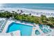 Beautiful aerial shot featuring a luxurious pool, spa, lush landscaping, and a pristine beach at 230 Sands Point Rd # 3501, Longboat Key, FL 34228