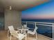 Balcony with an outdoor table and chairs, offering panoramic views of the ocean at dusk at 230 Sands Point Rd # 3501, Longboat Key, FL 34228