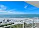 Balcony overlooking white sand beach and blue ocean waters, with lounge chairs and beach umbrellas at 230 Sands Point Rd # 3501, Longboat Key, FL 34228