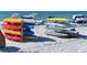 Rows of colorful kayaks and surfboards neatly stacked on a sandy beach, offering a variety of water sports activities at 230 Sands Point Rd # 3501, Longboat Key, FL 34228