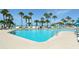 Inviting pool area surrounded by swaying palm trees, lounge chairs, and sun umbrellas at 230 Sands Point Rd # 3501, Longboat Key, FL 34228