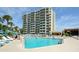 Exterior view of a large pool area with palm trees and lounge chairs surrounding it at 230 Sands Point Rd # 3501, Longboat Key, FL 34228