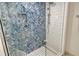 Modern shower with blue herringbone tile accent wall, glass door, and updated fixtures at 230 Sands Point Rd # 3501, Longboat Key, FL 34228