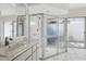 Bright bathroom featuring a glass shower, marble countertop, and white tiled floor at 23116 Amethyst Ave, Port Charlotte, FL 33952