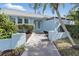 Charming home featuring a blue exterior, lovely landscaping, and a welcoming walkway to the front door at 23116 Amethyst Ave, Port Charlotte, FL 33952
