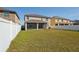 View of the backyard which features a lawn surrounded by a white privacy fence and backs to other homes in the neighborhood at 2332 Dovesong Trace Dr, Ruskin, FL 33570