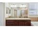 Bathroom with double sinks, large mirrors, and a soaking tub in a tiled setting at 2332 Dovesong Trace Dr, Ruskin, FL 33570