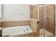 Elegant bathroom featuring a soaking tub and a glass-enclosed shower with tiled surround at 2332 Dovesong Trace Dr, Ruskin, FL 33570