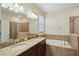 Bathroom featuring double sinks, granite countertops, a soaking tub, and separate glass shower at 2332 Dovesong Trace Dr, Ruskin, FL 33570