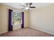 Neutral bedroom featuring plush carpet, a ceiling fan, and a window with dark purple coverings at 2332 Dovesong Trace Dr, Ruskin, FL 33570