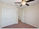 Bedroom with a ceiling fan, neutral walls, carpeted floor, a double-door closet, and white trim throughout at 2332 Dovesong Trace Dr, Ruskin, FL 33570