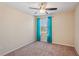Bright bedroom featuring a ceiling fan, a window with turquoise curtains, and carpeted floor at 2332 Dovesong Trace Dr, Ruskin, FL 33570