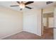 Neutral-toned bedroom featuring a ceiling fan, carpeted floor, and a closet with white bi-fold doors at 2332 Dovesong Trace Dr, Ruskin, FL 33570