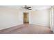 Bedroom features neutral walls, plush carpet, ceiling fan, and hall access at 2332 Dovesong Trace Dr, Ruskin, FL 33570