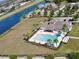 Aerial shot showcasing the community pool with palm trees, seating, a dog park, and a picturesque waterway at 2332 Dovesong Trace Dr, Ruskin, FL 33570