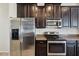Modern kitchen boasts stainless steel appliances, dark cabinets, and ample counter space at 2332 Dovesong Trace Dr, Ruskin, FL 33570