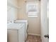 Functional laundry area with a washer, dryer, and wire shelving at 2332 Dovesong Trace Dr, Ruskin, FL 33570
