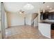 Open-concept living room with tile flooring, ceiling fan, and adjacent kitchen with dark cabinetry and bar seating at 2332 Dovesong Trace Dr, Ruskin, FL 33570