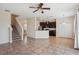 Spacious living room with tile floors, ceiling fan, and a view of the kitchen with dark cabinets and bar at 2332 Dovesong Trace Dr, Ruskin, FL 33570