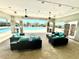 A covered outdoor lounge area with ceiling fans, patio furniture and views of the nearby community swimming pool at 2332 Dovesong Trace Dr, Ruskin, FL 33570