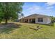 Large backyard featuring a covered patio, vinyl fence, and mature landscaping at 2396 Malibu Ln, North Port, FL 34286
