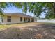 Spacious backyard with covered patio, view of the house, and white vinyl fence at 2396 Malibu Ln, North Port, FL 34286