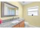 Bathroom featuring granite counter, wooden cabinet, and window providing ample lighting at 2396 Malibu Ln, North Port, FL 34286