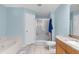 Bright bathroom with blue walls, shower, tub, and a marble countertop sink at 2396 Malibu Ln, North Port, FL 34286