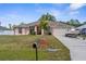 Charming single-story home with well-manicured lawn and a driveway with a boat parked on it at 2396 Malibu Ln, North Port, FL 34286