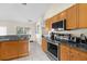Well-lit kitchen features granite countertops, stainless steel appliances, and wood cabinets at 2396 Malibu Ln, North Port, FL 34286