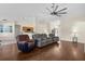 Open-concept living room with hardwood floors, gray sofas, and access to the kitchen at 2396 Malibu Ln, North Port, FL 34286