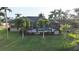 Aerial view of the backyard featuring a screened lanai and pool, surrounded by lush greenery and a tranquil lake at 24342 Saragossa Ln, Punta Gorda, FL 33955