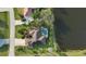 Aerial view of a house with a pool, set by a lake, complemented by lush landscaping and solar panels at 24342 Saragossa Ln, Punta Gorda, FL 33955