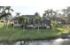 Beautiful backyard with a screened-in pool, lush greenery, and waterfront view at 24342 Saragossa Ln, Punta Gorda, FL 33955