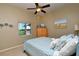 Bedroom with neutral colored walls featuring bed, dresser with TV and coastal wall decor at 24342 Saragossa Ln, Punta Gorda, FL 33955