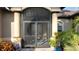 Elegant screened front entrance with decorative glass doors and manicured landscaping, creating a welcoming curb appeal at 24342 Saragossa Ln, Punta Gorda, FL 33955