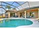 Inviting screened-in pool area with patio seating, perfect for outdoor relaxation and entertaining with views of the home's interior at 24342 Saragossa Ln, Punta Gorda, FL 33955