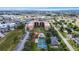Aerial view of condo complex with a swimming pool, tennis courts and lush landscaping at 3006 Caring Way # 210, Port Charlotte, FL 33952