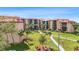 Aerial view showcases beautiful grounds of the condo complex with landscaping, sidewalks, and palm trees at 3006 Caring Way # 210, Port Charlotte, FL 33952