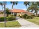 Exterior of a clubhouse with lush landscaping and ample parking at 3006 Caring Way # 210, Port Charlotte, FL 33952