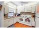 Bright kitchen featuring white cabinetry, double ovens, and tile backsplash at 3006 Caring Way # 210, Port Charlotte, FL 33952