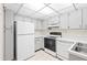 Efficient kitchen featuring white appliances and ample cabinet space at 3006 Caring Way # 210, Port Charlotte, FL 33952