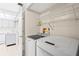 Laundry area with a washer, dryer, storage shelves, and ample room for folding laundry at 3006 Caring Way # 210, Port Charlotte, FL 33952
