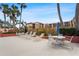 Relaxing pool area featuring lounge chairs and tables under a sunny sky at 3006 Caring Way # 210, Port Charlotte, FL 33952