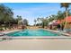 Community pool surrounded by palm trees and lounge chairs at 3006 Caring Way # 210, Port Charlotte, FL 33952