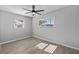 A bright bedroom is enhanced by the natural light from two windows, complete with a modern ceiling fan and wood-look floors at 3169 Bellevue St, Sarasota, FL 34237