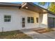 Close up view of the entrance to a charming, one-story home with gray trim and a manicured lawn at 3169 Bellevue St, Sarasota, FL 34237