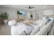 Bright living room featuring a ceiling fan, large TV, and stylish white sectional sofa with striped pillows and rug at 3508 Anchor Bay Trl, Lakewood Ranch, FL 34211